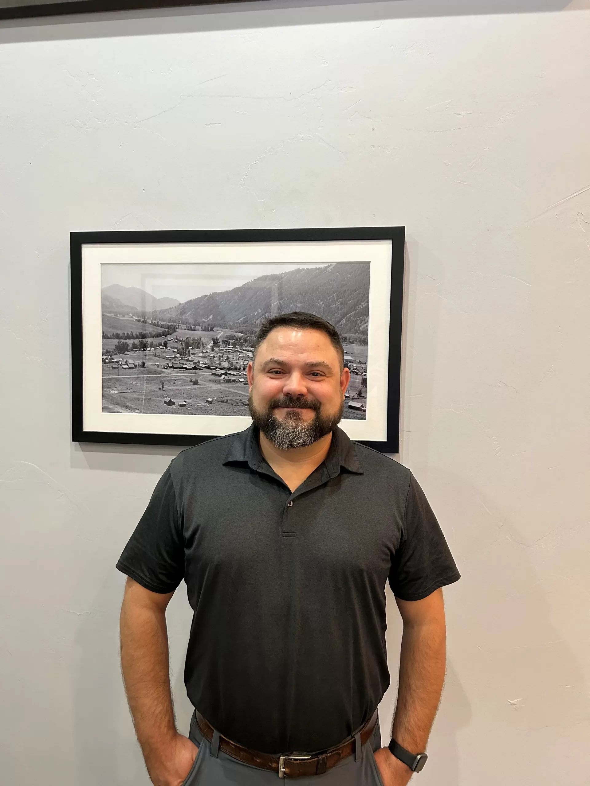 Darren Bearup, Project Manager for Soundwave Inc. in Ketchum, ID, stands before a black and white photograph of Ketchum.